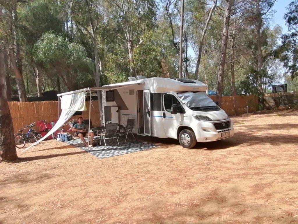 Wohnmobil Pfritzi mit Markise und Sonnensegel auf einem Campingplatz in Spanien